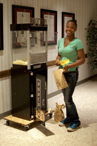 Raigan Dantzler, serving those who come to the event with fresh popcorn accompanied with various flavorings.