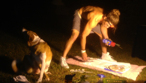Chad A., with the company of his dog, takes advantage of a quiet night in Shepherdstown to create custom clothing on the lawn of Reynolds Hall.