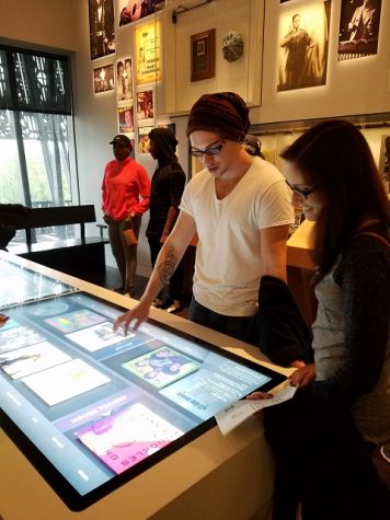 Shepherd students James Walker and Megan Murray use an interactive display to set the playlist that plays over the musical exhibit.